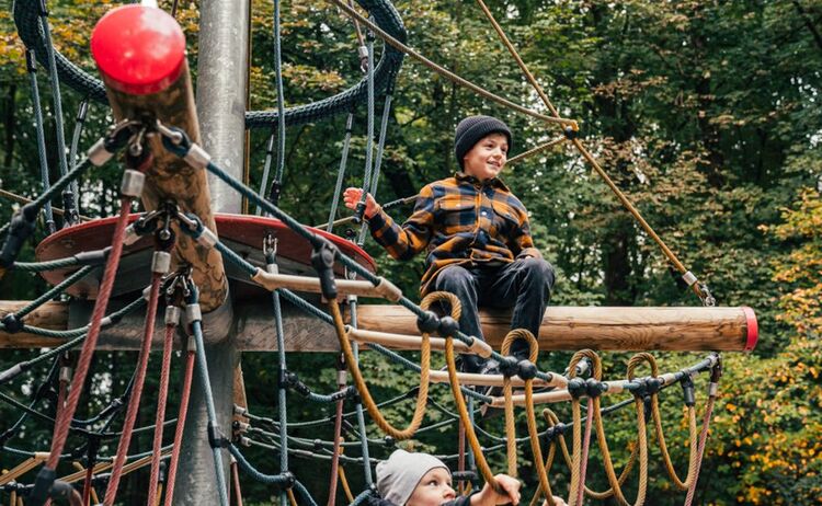 Zwei Jungs klettern auf einem Klettergerüst auf dem Spielplatz: Zum Vergrößern auf Bild klicken