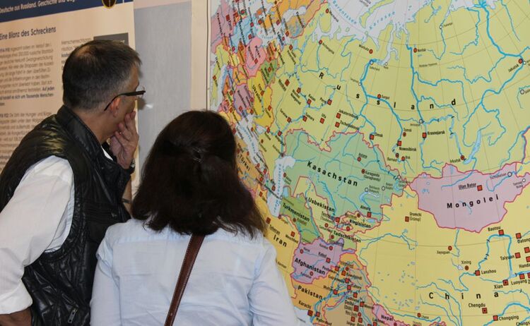 Zwei Besucher betrachten eine Landkarte der Ausstellung Deutsche aus Russland: Zum Vergrößern auf Bild klicken