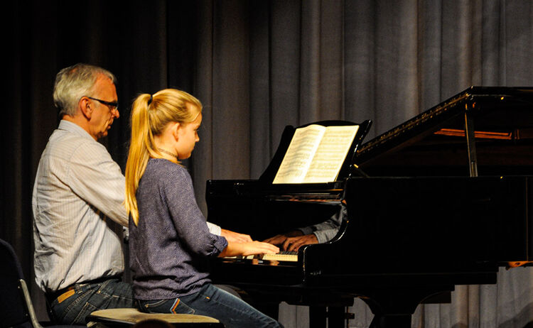 Ein Musikschullehrerin spielt mit seiner Schülerin am Klavier: Zum Vergrößern auf Bild klicken