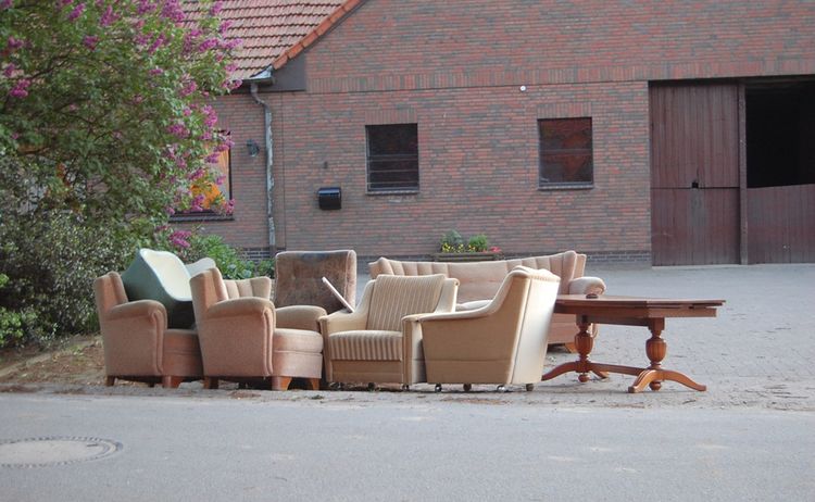 Sperrmüll am Straßenrand eine altes Sofa, ein Tisch und mehrer Sessel vor einem Haus: Zum Vergrößern auf Bild klicken
