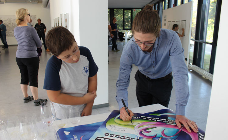 Ein Junge unterhält sich bei der Ausstellung Comic Future: Zum Vergrößern auf Bild klicken