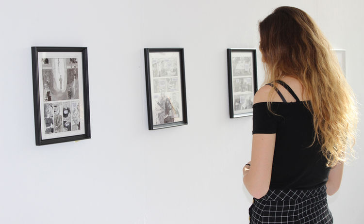 Eine Besucherin betrachtet die Comics der Ausstellung Comic Future: Zum Vergrößern auf Bild klicken