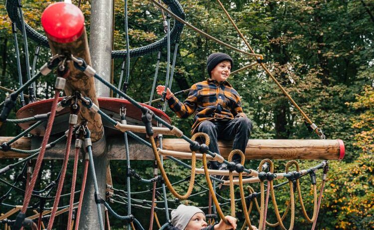 Zwei Jungs klettern auf einem Klettergerüst auf dem Spielplatz: Klick öffnet eine vergrößerte Ansicht