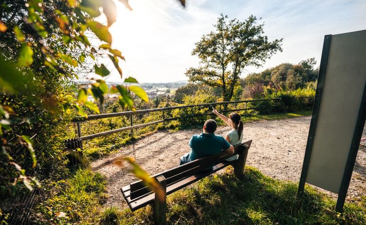 Eine Frau und ein Mann sitzen auf einer Bank und genießen den Ausblick in das Inntal: Klick öffnet eine vergrößerte Ansicht