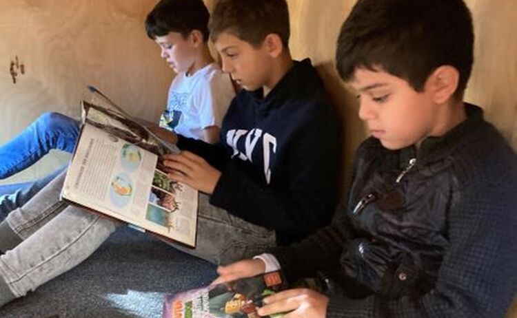 Nach der Paul-Maar-Büchereiführung - Jungs beim schmökern im Märchenhaus: Klick öffnet eine vergrößerte Ansicht