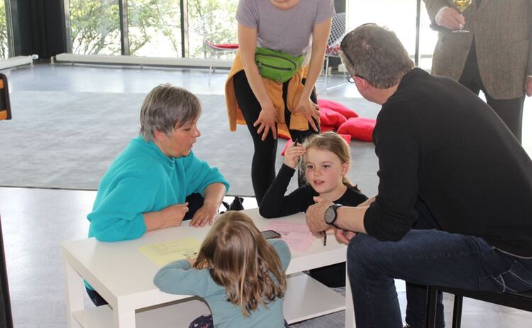 Kinder mit ihren Eltern beim Ausfüllen des Museumsrätsels: Klick öffnet eine vergrößerte Ansicht