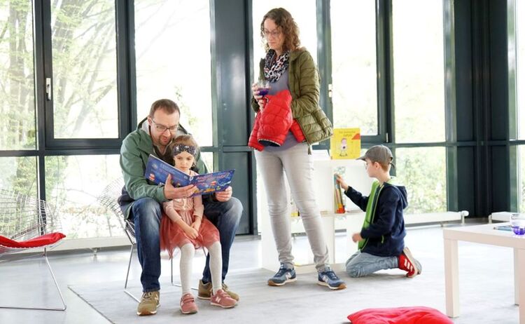 Eine Familie in der Leseecke der Ausstellung: Klick öffnet eine vergrößerte Ansicht