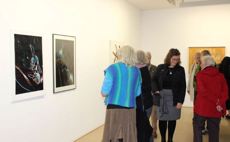 Besucherinnen und Besucher vor Fotografien aus den 1990er Jahren: Zum Vergrößern auf Bild klicken