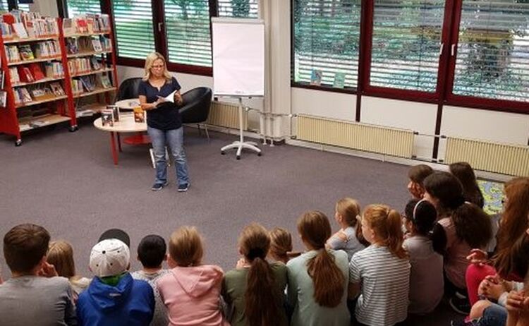 Autorin Susanne Knaus liest bei einer Autorenbegegnung im Haus des Buches Kindern vor: Klick öffnet eine vergrößerte Ansicht