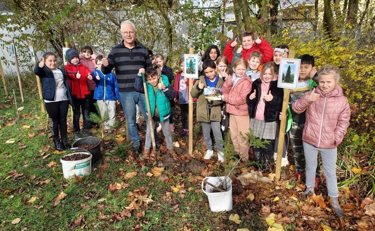 Gruppenfoto der Schüler der Graslitzer Grundschule mit Stadtgärtner Christian Stöckl beim Pflanzen der Bäume: Klick öffnet eine vergrößerte Ansicht