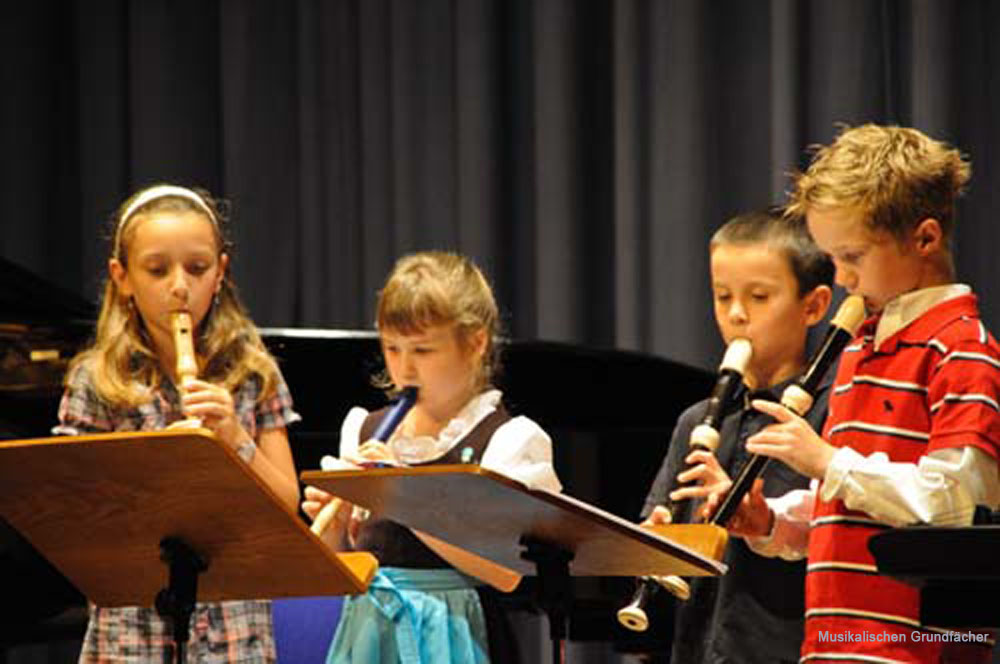 Vier Schüler der Musikschule spielen Flöte auf der Bühne Vier Schüler der Musikschule spielen Flöte auf der Bühne