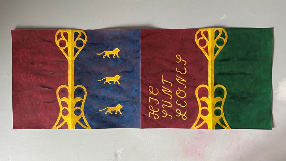 Cover des zur Ausstellung erscheinenden Katalogs. Im Vordergrund R&uuml;ckseite blau mit drei gelben L&ouml;wen