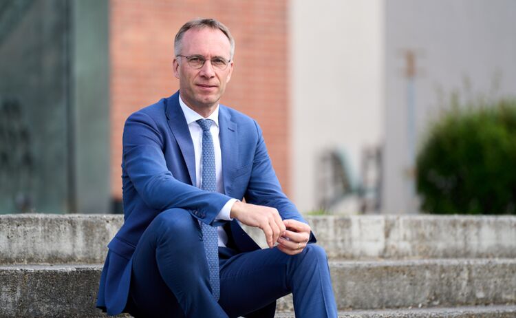 Portraitfoto von Bürgermeister Robert Pötzsch auf einer Treppe