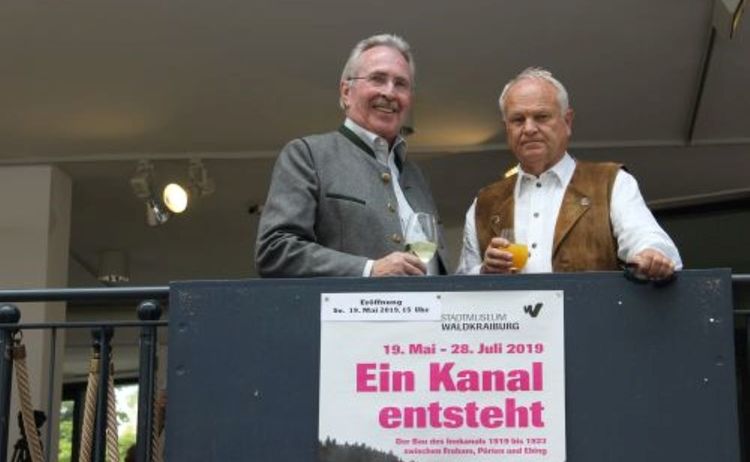 Ehemaliger Landrat Georg Huber und Altbürgermeister Siegfried Klika im Gespräch bei der Eröffnung der AusstellungEin Kanal entsteht: Klick öffnet eine vergrößerte Ansicht