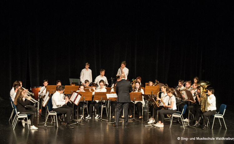 Das Ensemble der Sing- und Musikschule bei einem Auftritt auf der Bühne im Haus der Kultur: Klick öffnet eine vergrößerte Ansicht