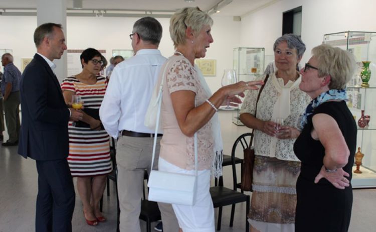 Besucher diskutieren über die Ausstellungsstücke der Ausstellung Rimpler Glas: Zum Vergrößern auf Bild klicken