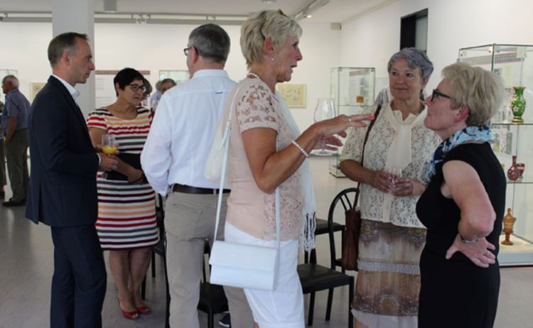 Besucher diskutieren über die Ausstellungsstücke der Ausstellung Rimpler Glas: Klick öffnet eine vergrößerte Ansicht