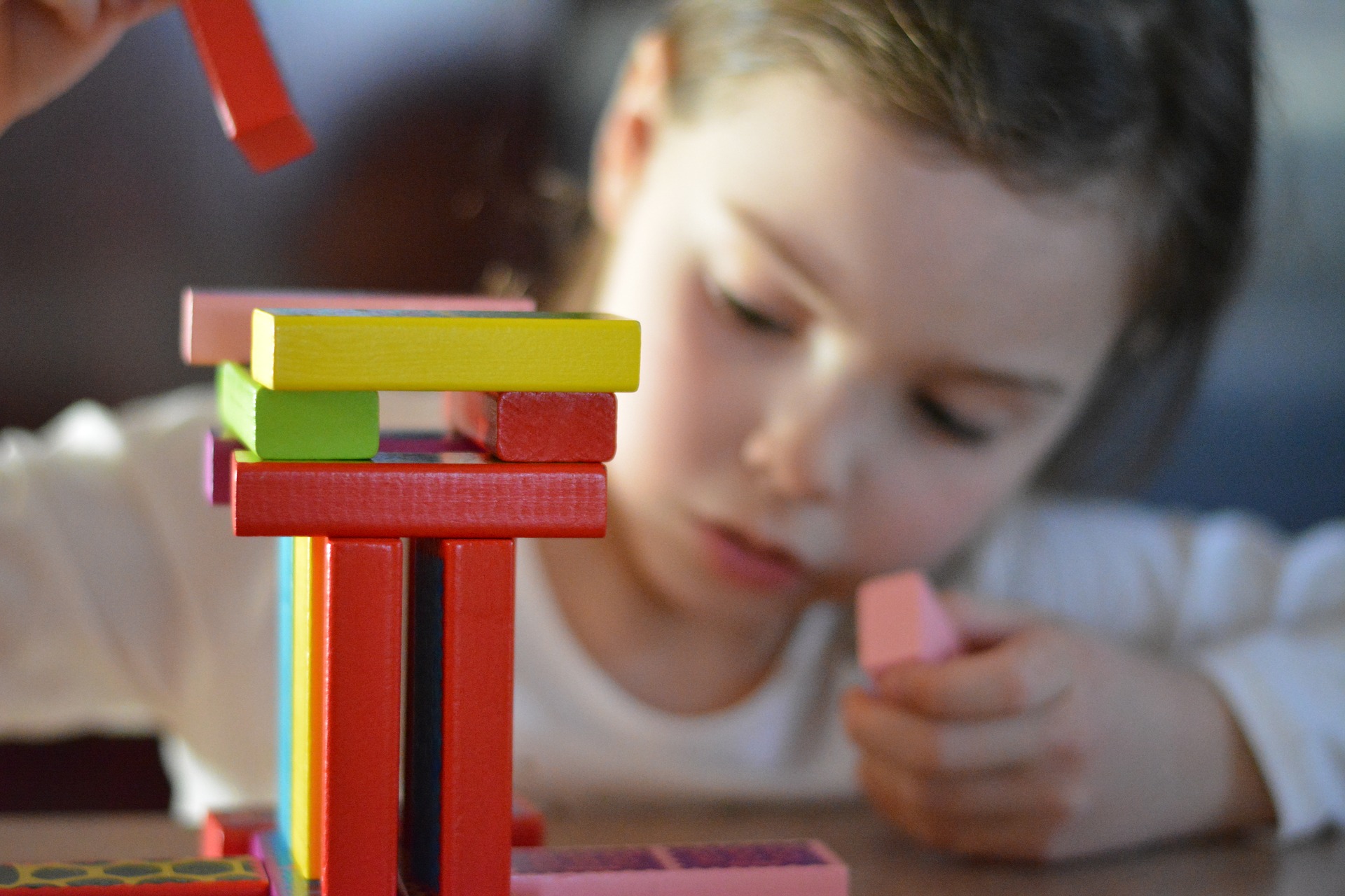 Ein Mädchen spielt mit Bauklötzen im Kindergarten 