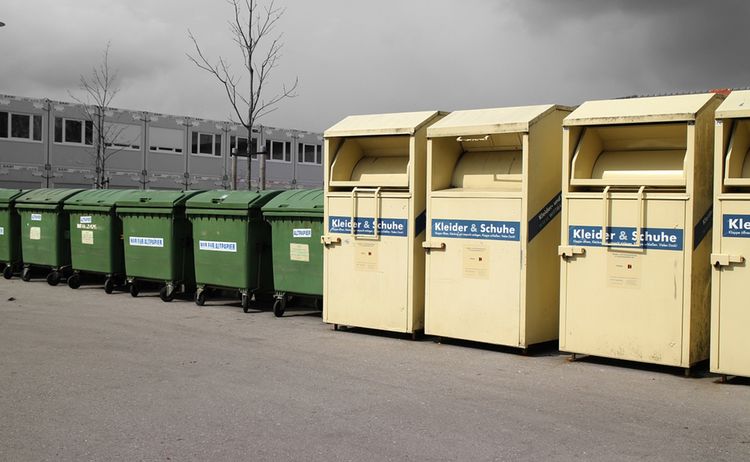 4 Altkleidercontainer und mehrere Grünen Tonnen stehen an einer Straße entlang: Zum Vergrößern auf Bild klicken