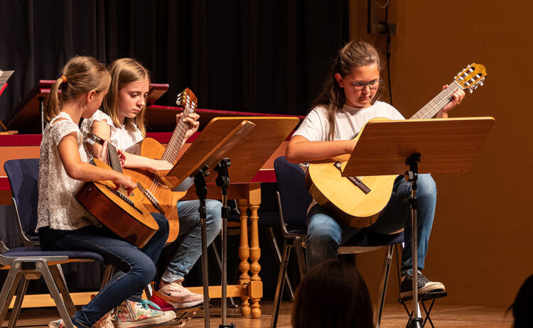 Drei Mädchen der Musikschule spielen Gitarre auf der Bühne : Klick öffnet eine vergrößerte Ansicht