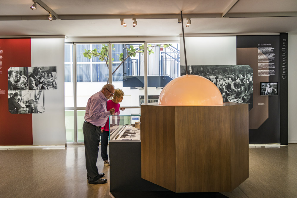 Zwei Besucher sehen sich die Exponate im Glasmuseum an