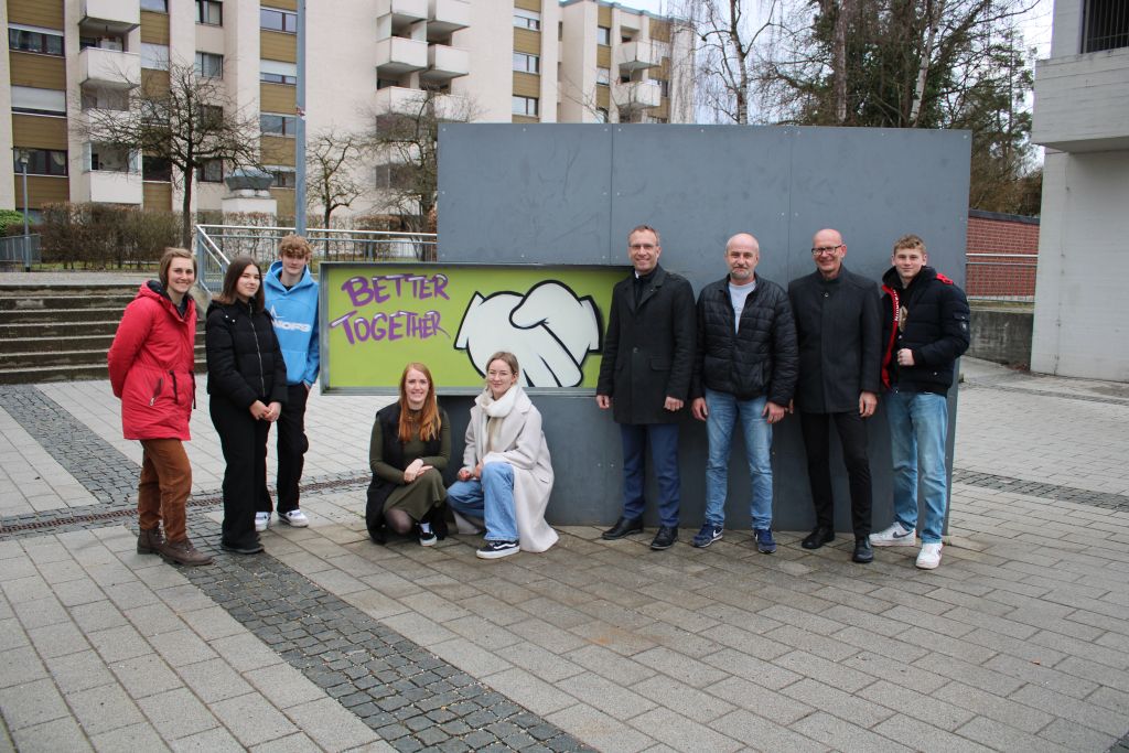 Gruppenfoto vor einem der Kunstwerke des Graffitiworkshops 