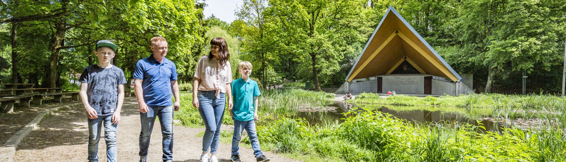 Eine vierköpfige Familie geht im Stadtpark spazieren