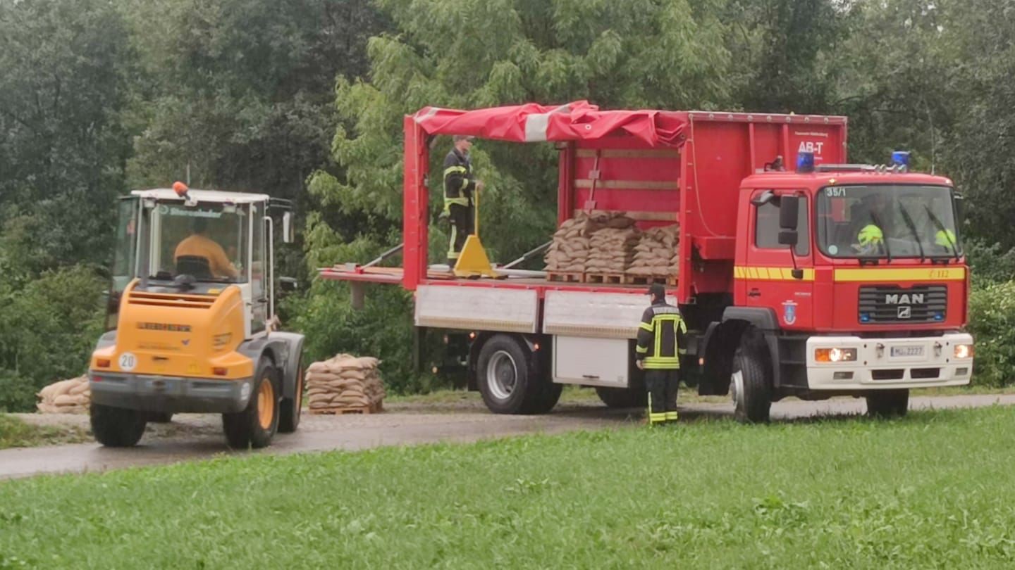 Das Feuerwehrauto wird mit Sandsäcken beladen