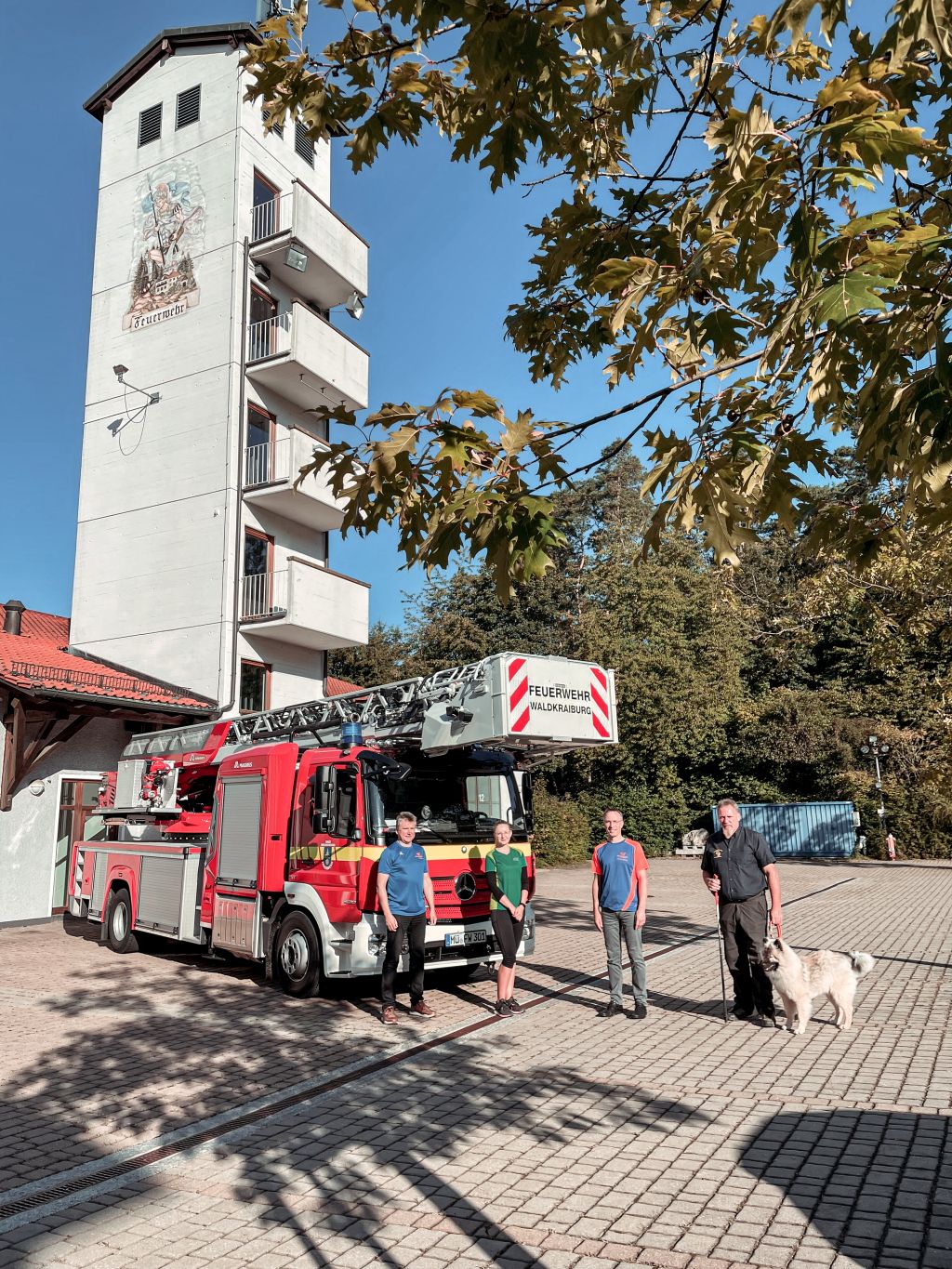 Feuerwehr Kommandant Bernhard Vietze, AOK Geschäftsstellenleiterin Regina Rasch, Erster Bürgermeister Robert Pötzsch und Kreisbrandmeister Anton Bruckeder stehen vor der Drehleiter der Waldkraiburger Feuerwehr