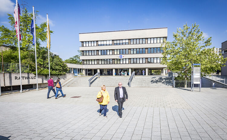 Bürger spazieren auf dem Rathausvorplatz 