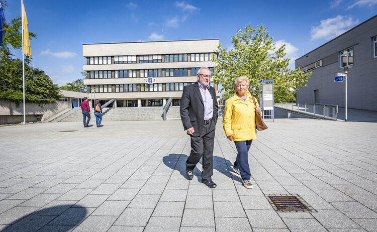 Zwei Senioren spazieren am Rathaus Vorplatz 