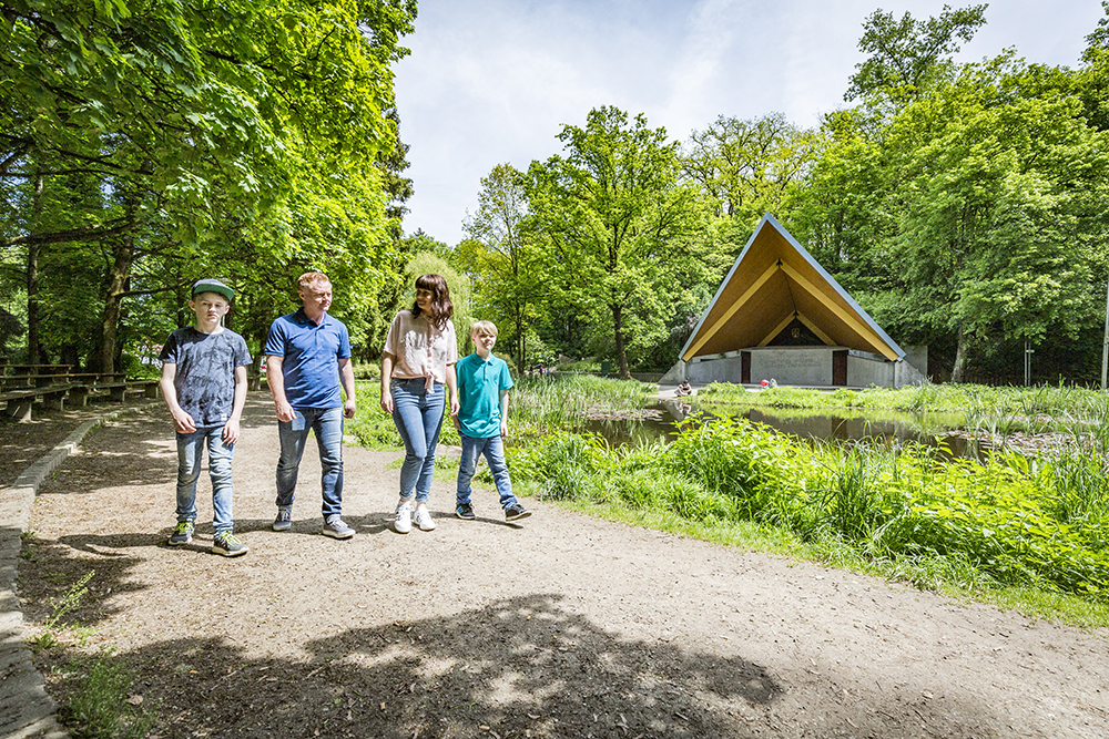 Eine vierköpfige Familie geht im Stadtpark spazieren 