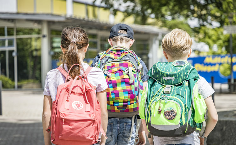 Schulkinder von hinten mit ihren Rucksäcken : Zum Vergrößern auf Bild klicken