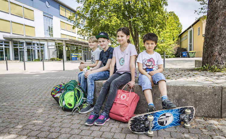 Kinder sitzen am Pausenhof: Zum Vergrößern auf Bild klicken