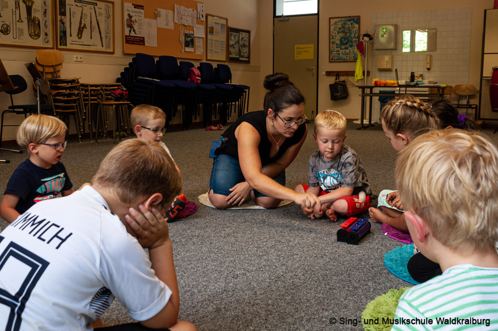 Kinder sitzen bei der Musikalische Früherziehung der Musikschule im Kreis