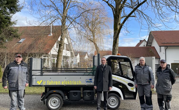 Die Mitarbeiter des Waldfriedhofes und Erster Bürgermeister Robert Pötzsch stehen vor dem neuen E-Fahrzeug des Waldfriedhofes
