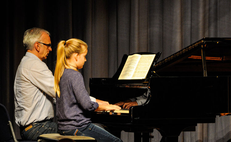 Ein Musikschullehrerin spielt mit seiner Schülerin am Klavier: Klick öffnet eine vergrößerte Ansicht