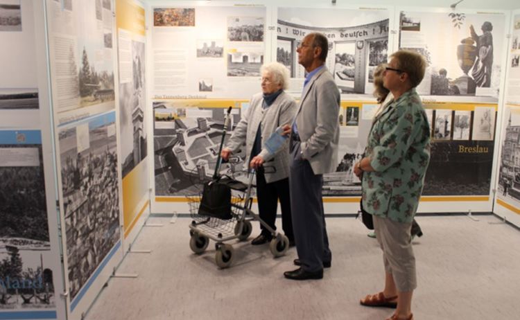 Besucher beim Betrachten der Ausstellung Verschwundene Orte: Klick öffnet eine vergrößerte Ansicht